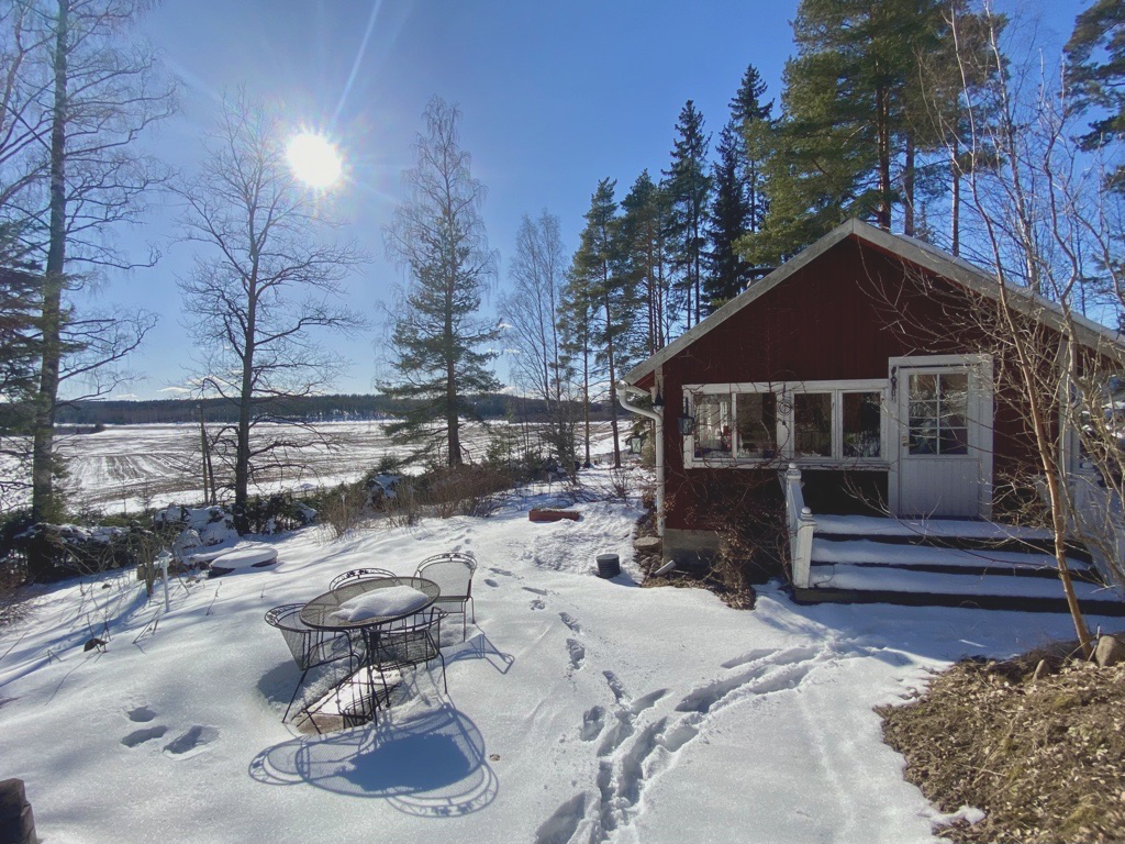 Mökki keväthankien keskellä.